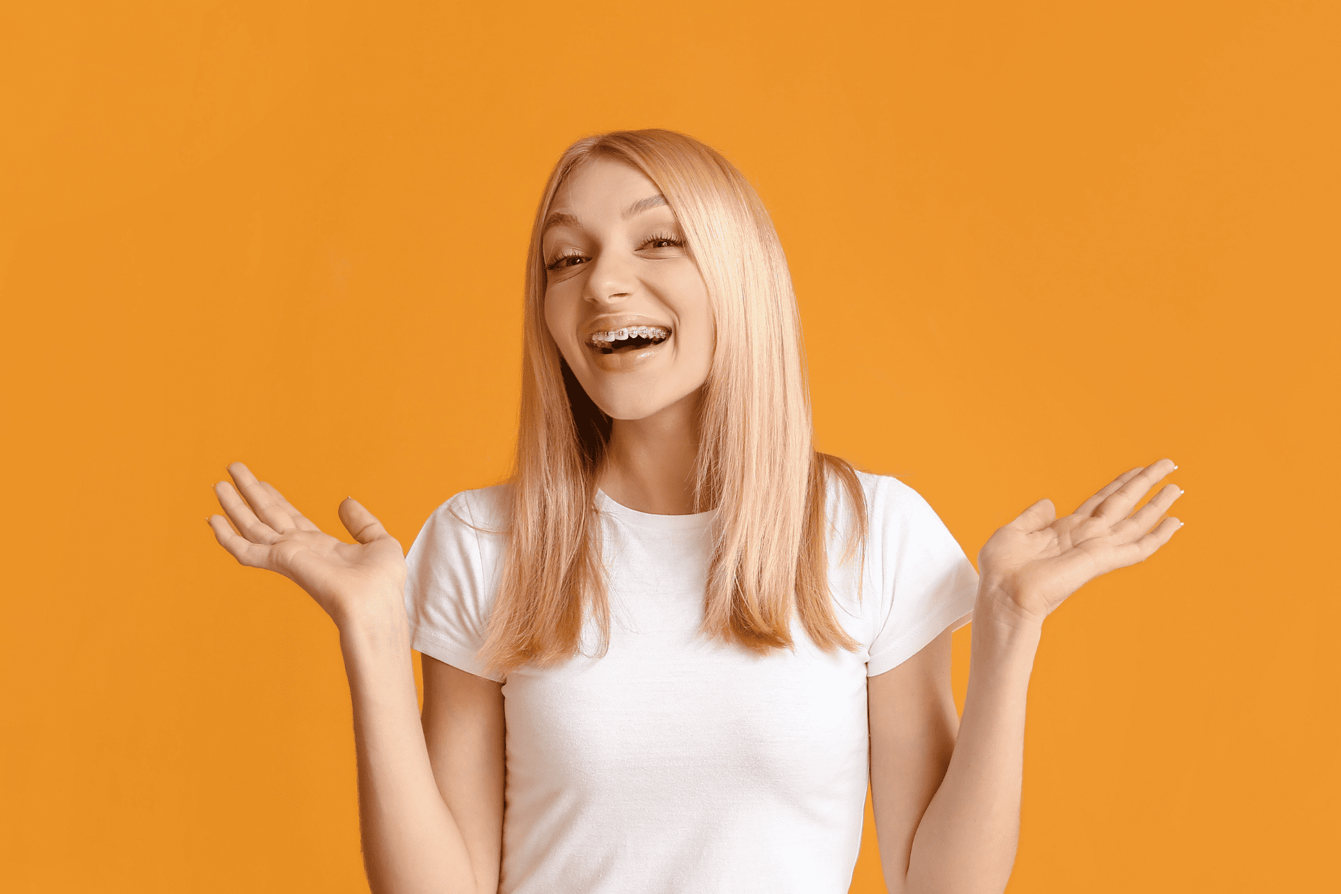 girl with braces on orange background